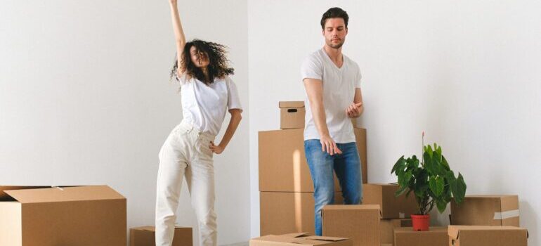 Man and woman dancing next to moving boxes
