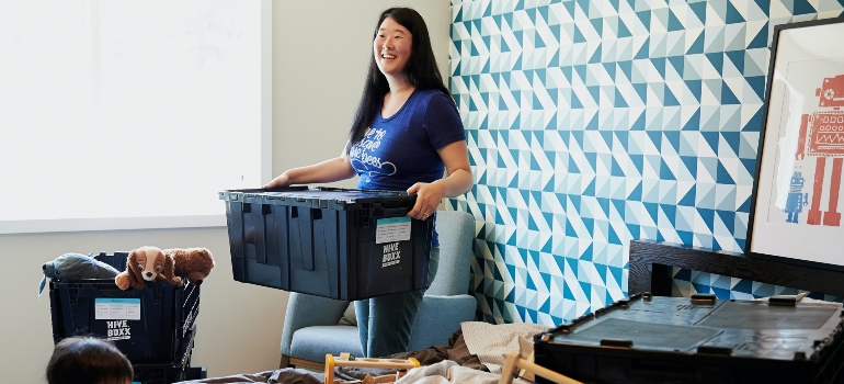 woman in blue t shirt carry the plastic box