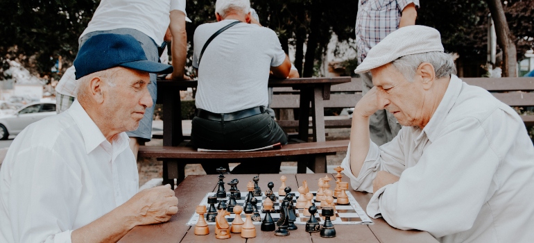 Two seniors playing chess outside