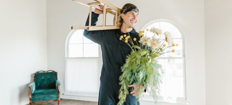 a member of a team of best cross country movers Shawnee carrying a stool and a pot of flowers