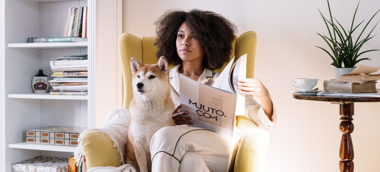 Woman reading a book with a dog 