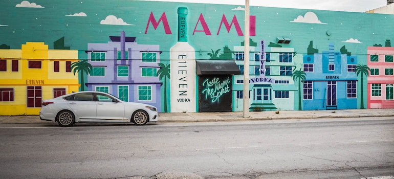 A colorful street with graffiti of building and a sign that says Miami on the wall