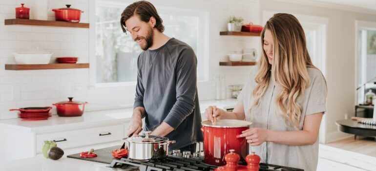 Couple preparing a meal together and talking about hiring best cross country movers Lenexa