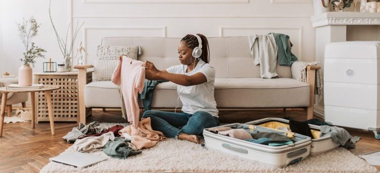 Woman sitting on the floor while packing