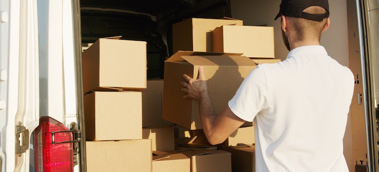 A man putting a box into a truck