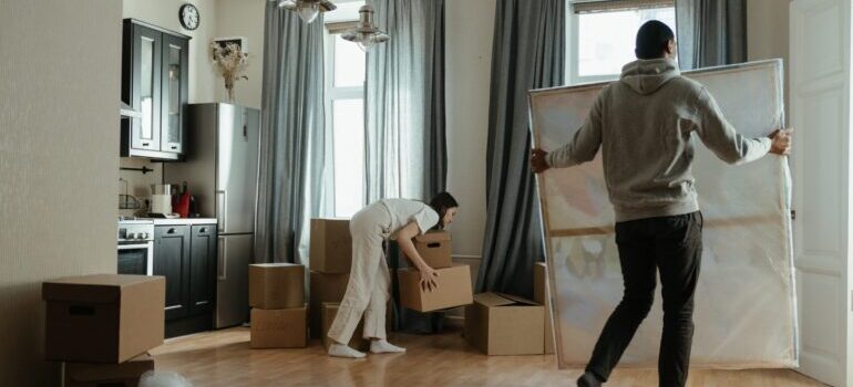 Two people setting up items in their new home