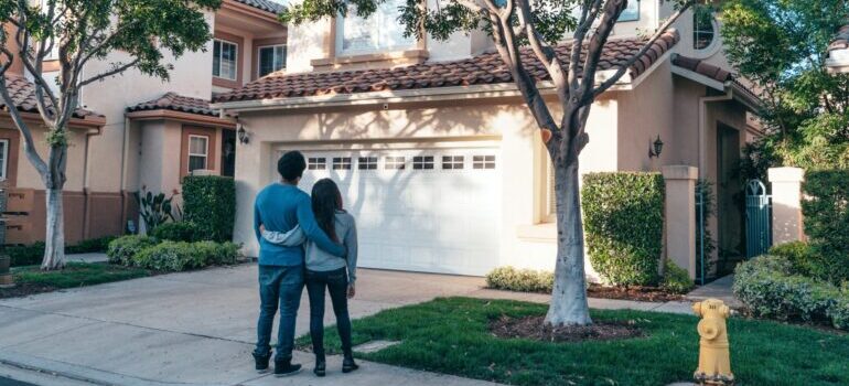 A couple standing in front of their new house