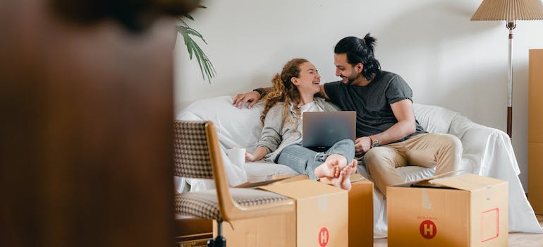 Two people sitting on the couch after moving with best cross country movers Burlington