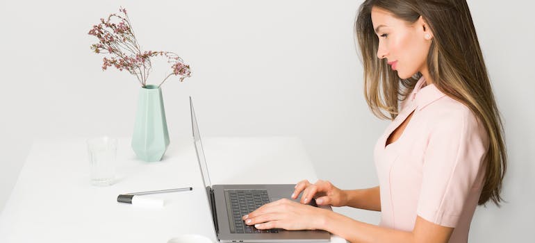 a woman in beige reading how to balance automation and personalized customer service on a laptop