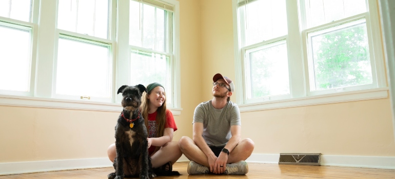 Picture of a couple and their pet in a new home 