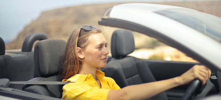 woman in yellow shirt driving a car