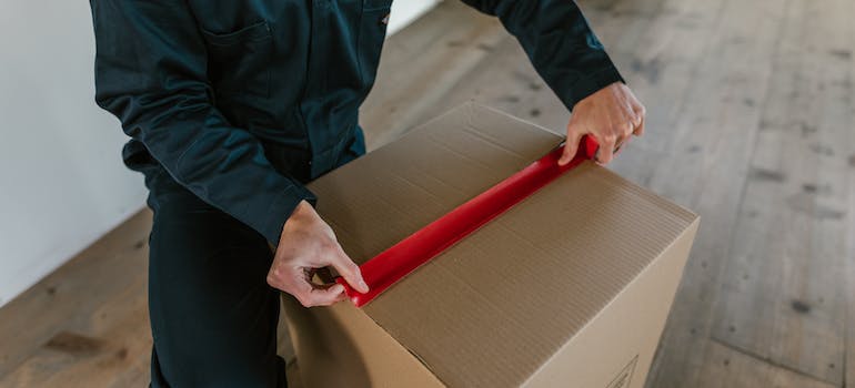 A man sealing the cardboard box