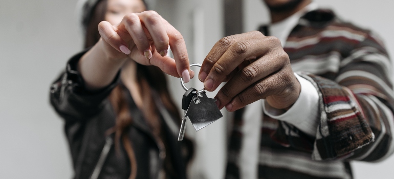 A couple holding the keys to their new apartment.