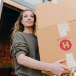 woman holding a big box and preparing for moving from Memphis to Fort Worth