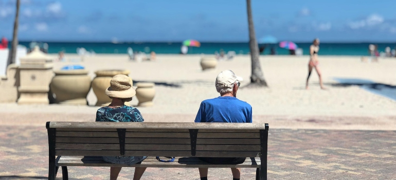 an elderly couple sitting on a bench after moving from San Diego to Miami