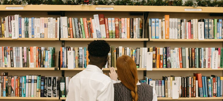 a man and a woman looking at a bookshelf