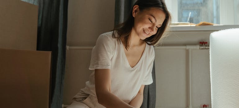 A woman trying to pack a bedroom