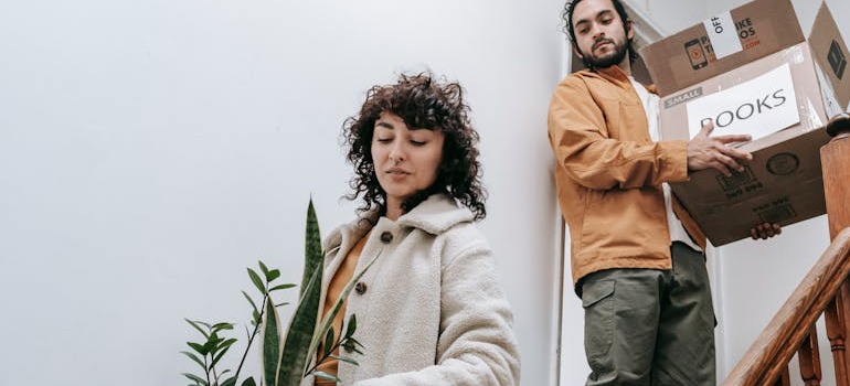 A couple successfully trying to pack a bedroom