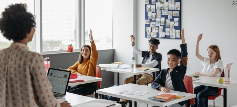 students with raised hands in class